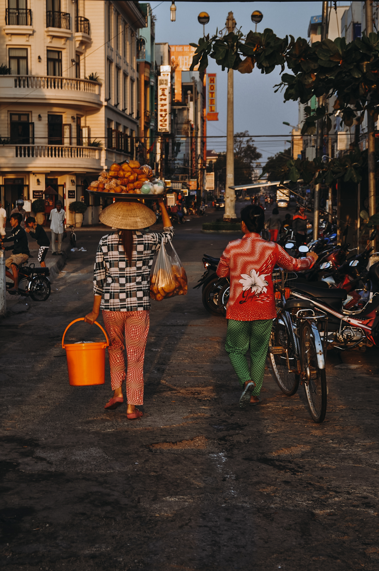 A woman carrying food on her head in Vietnam